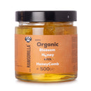 Jar of Raw Gorilla organic blossom honey with a cut honeycomb section, 500g