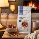 Salted Caramel Nut Mix pouch - cosy movie-night lifestyle with a bowl of caramelised nuts and hot chocolate