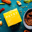 Close-up of Payst Thai Yellow Curry Paste being added to a skillet, highlighting rich texture and natural ingredients.