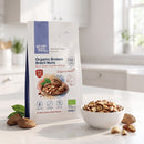 Organic Broken Brazil Nuts 250g pouch on a kitchen counter with a bowl of nut pieces