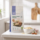 Organic Flaked Almonds 125g pouch on a kitchen counter with a bowl of flaked almonds